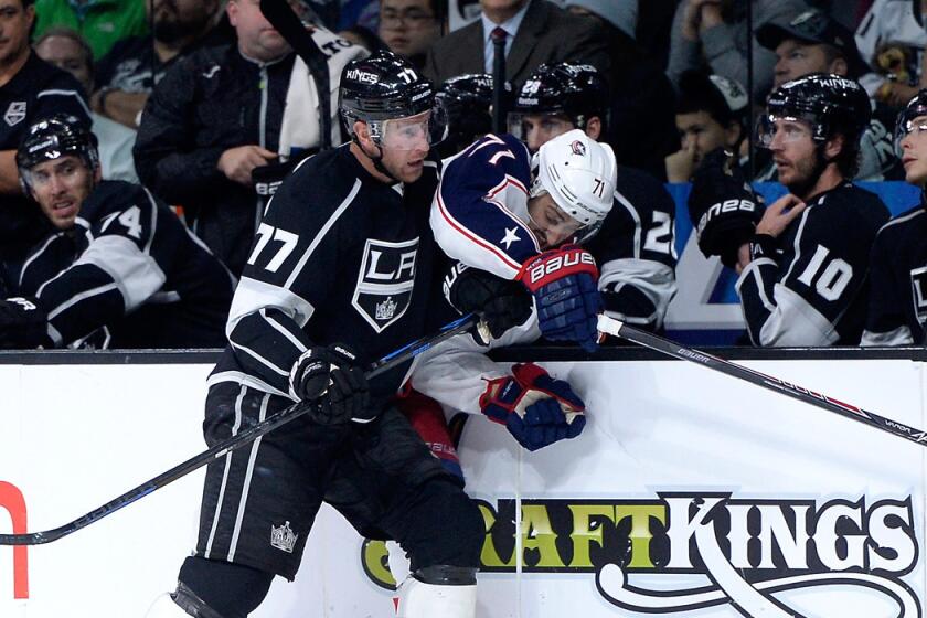 Kings forward Jeff Carter checks Blue Jackets left wing Nick Foligno into the boards. Foligno collided with a linesman and was injured on the play.