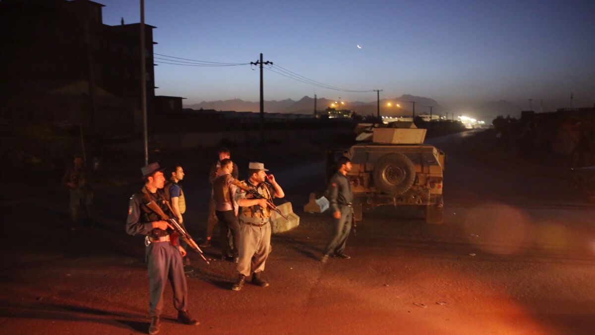 Afghan police block a road leading to the site of an explosion in Kabul.