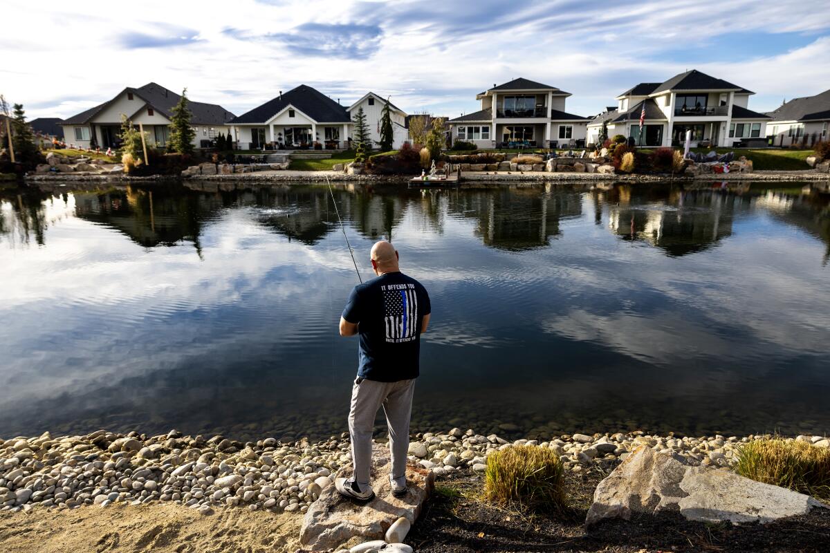 A retired 30-year veteran of the Los Angeles County Sheriff's Department fishes behind his new home on a man-made pond. 