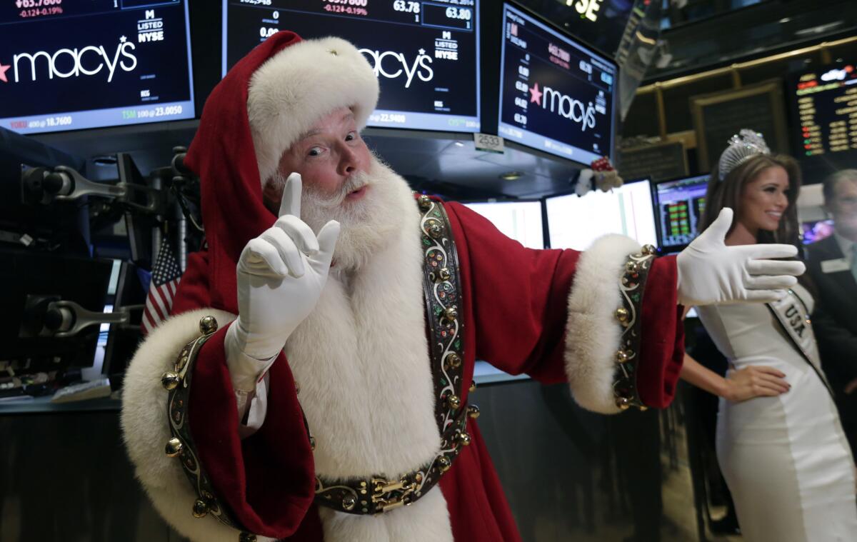 Santa Claus and Nia Sanchez, Miss USA 2014, who will be in the Macy's Thanksgiving Day Parade, visit the trading floor after participating in opening bell ceremonies of the New York Stock Exchange, Wednesday.