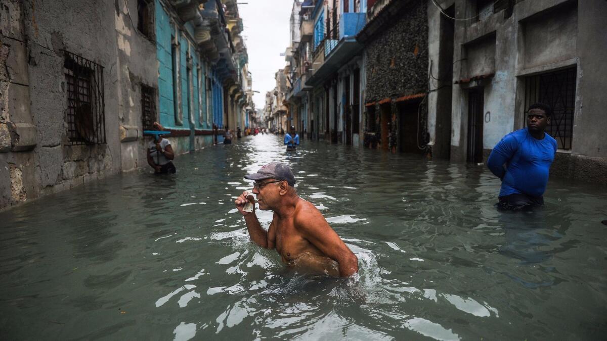 Cubans wade through a flooded street in Havana on Sunday.