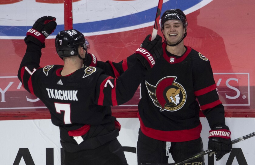 Ottawa Senators center Josh Norris, right, celebrates his overtime goal against the Toronto Maple Leafs with left wing Brady Tkachuk in an NHL hockey game Wednesday, May 12, 2021, in Ottawa, Ontario. (Adrian Wyld/The Canadian Press via AP)