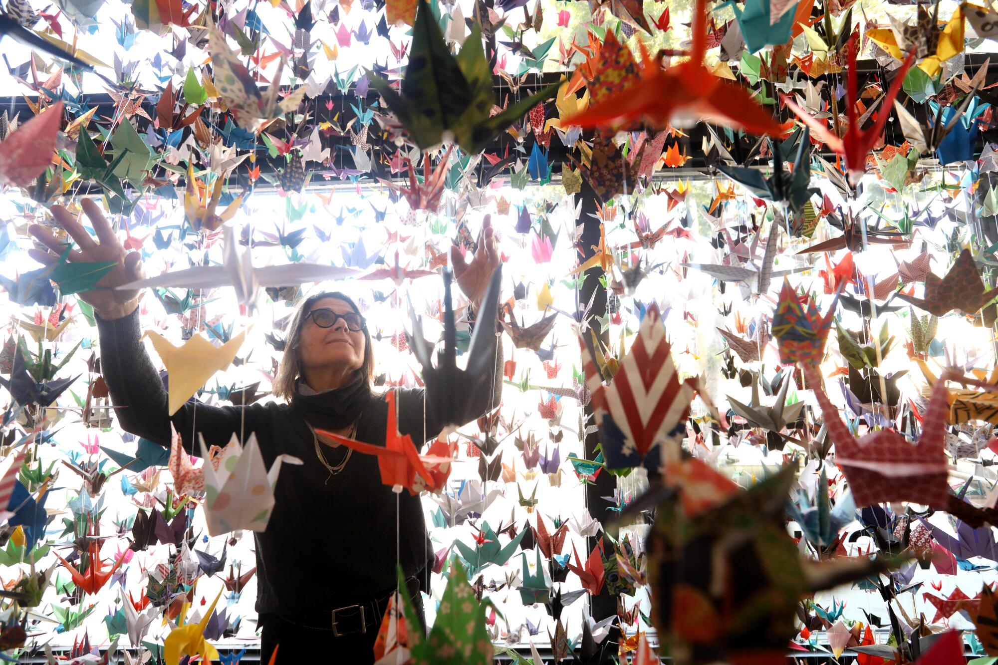A woman and hanging paper cranes