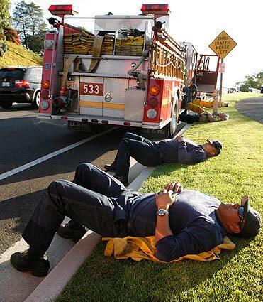Fire crews from Los Angeles County Fire rest while they wait for their assignment in Rancho Palos Verdes.