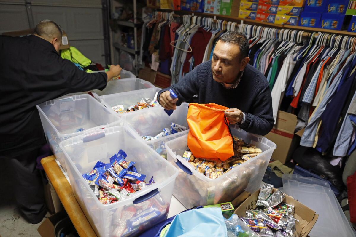 Mike Benavides, left, and Sergio Cordova prepare snack bags at their Brownsville home.