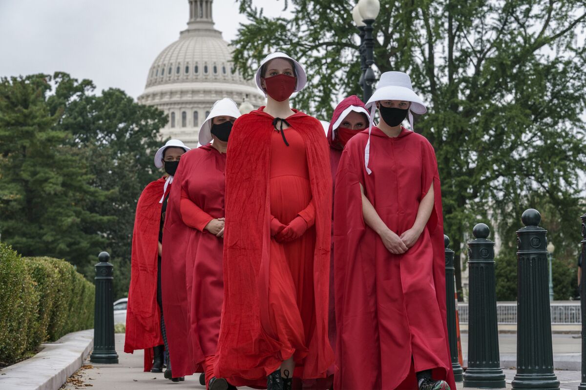 Activists dressed as characters from "The Handmaid's Tale" protest Sunday on Capitol Hill in Washington, D.C.