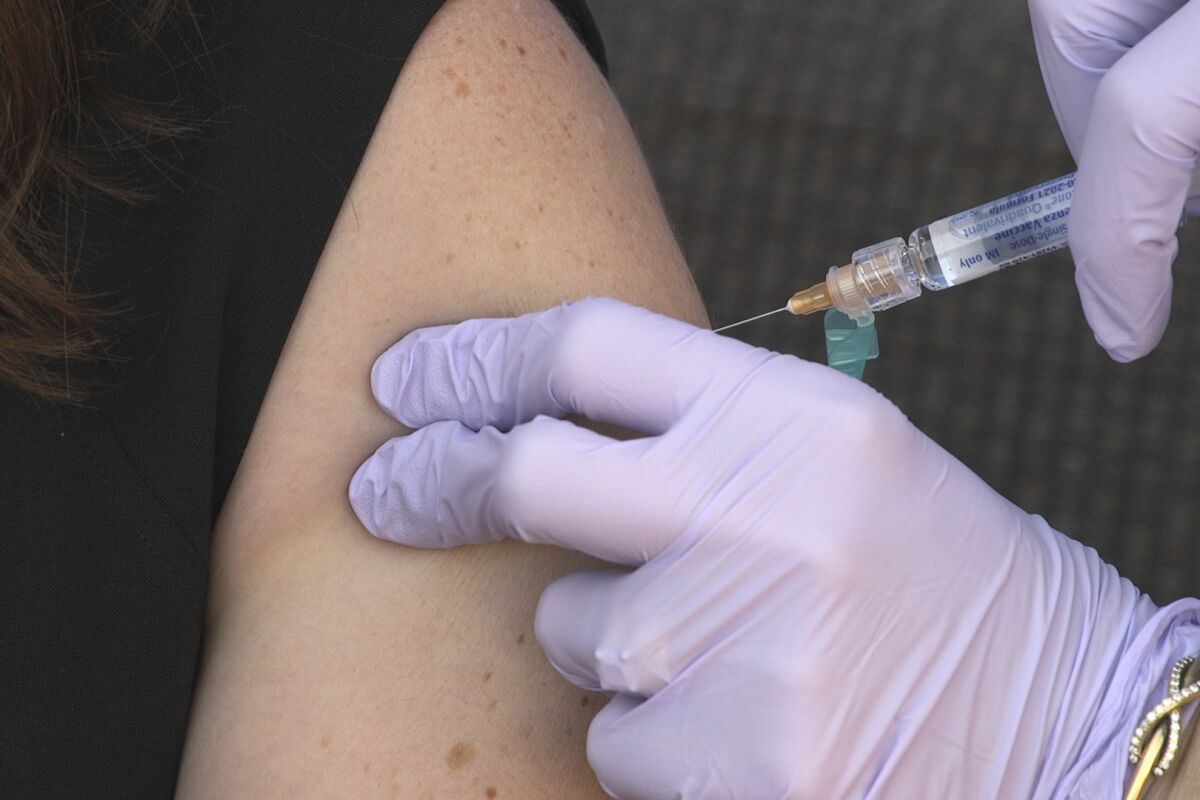 A person being given a shot in the arm.