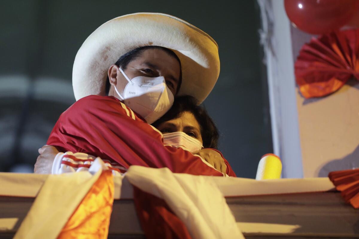 ARCHIVO - Pedro Castillo abraza a su esposa Lilia Paredes Navarro frente a sus simpatizantes 