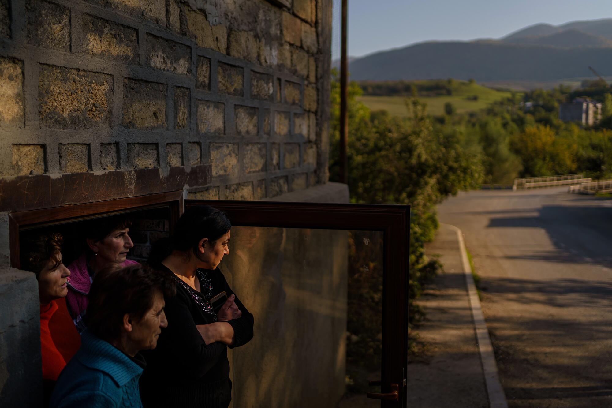 Four resident look out from the doorway of their basement shelter in Karmir Shuka, Nagorno-Karabakh.