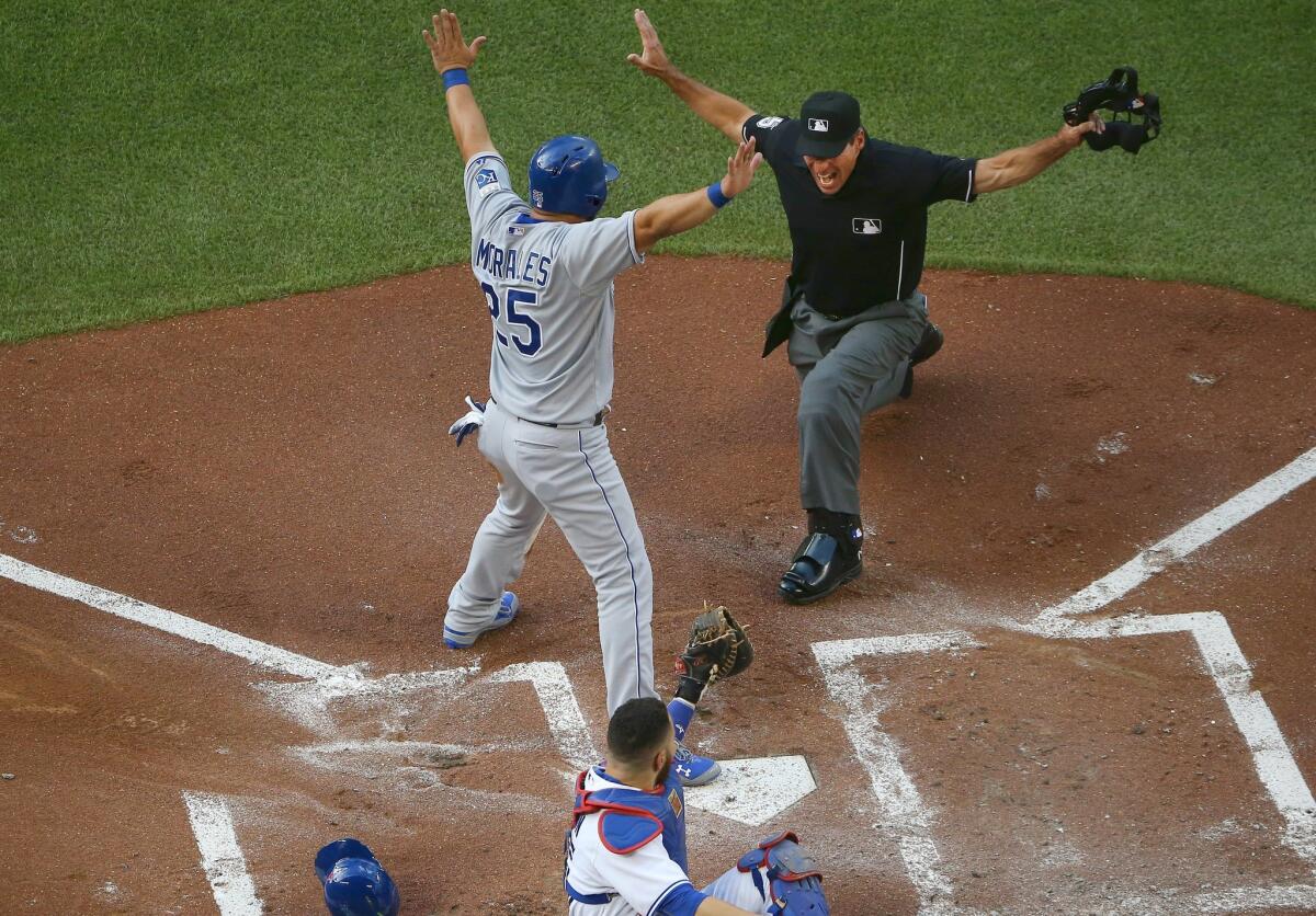 Kansas City's Kendrys Morales is called safe at home plate as Toronto catcher Russell Martin shows the ball to home plate umpire Angel Hernandez at Rogers Centre on Friday.
