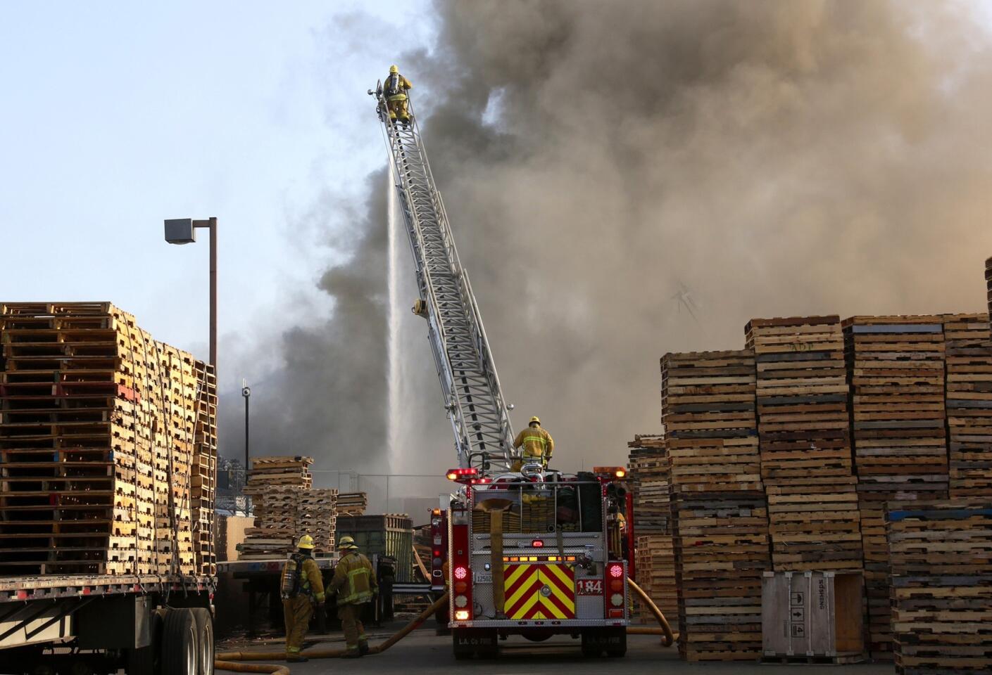 Firefighters work to extinguish a fire at a recycling business in Pomona on Wednesday morning.