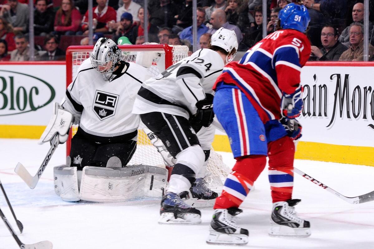 Kings goalie Martin Jones makes a save on a backhand shot by Montreal's David Desharnais, right, as Kings forward Colin Fraser looks on during the Kings' 6-0 win Tuesday.