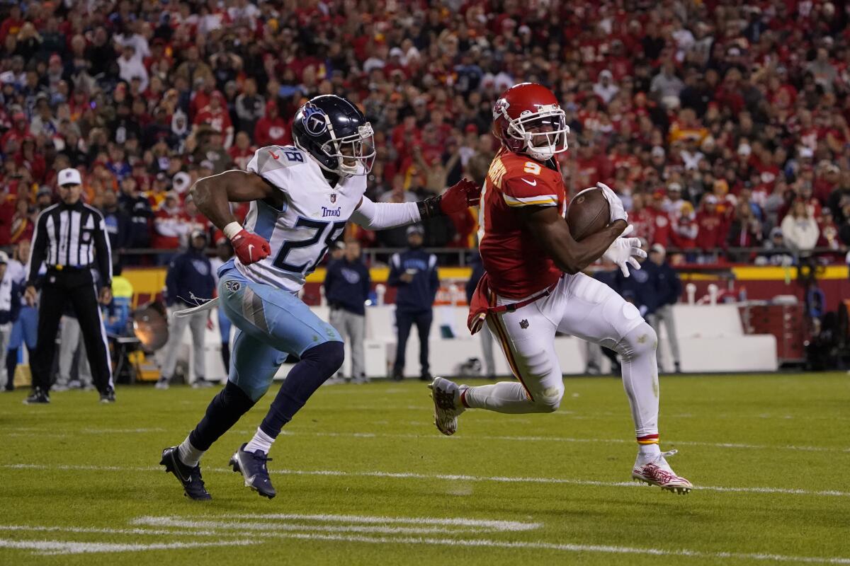 Kansas City Chiefs wide receiver JuJu Smith-Schuster catches a pass against Tennessee Titans safety Joshua Kalu.