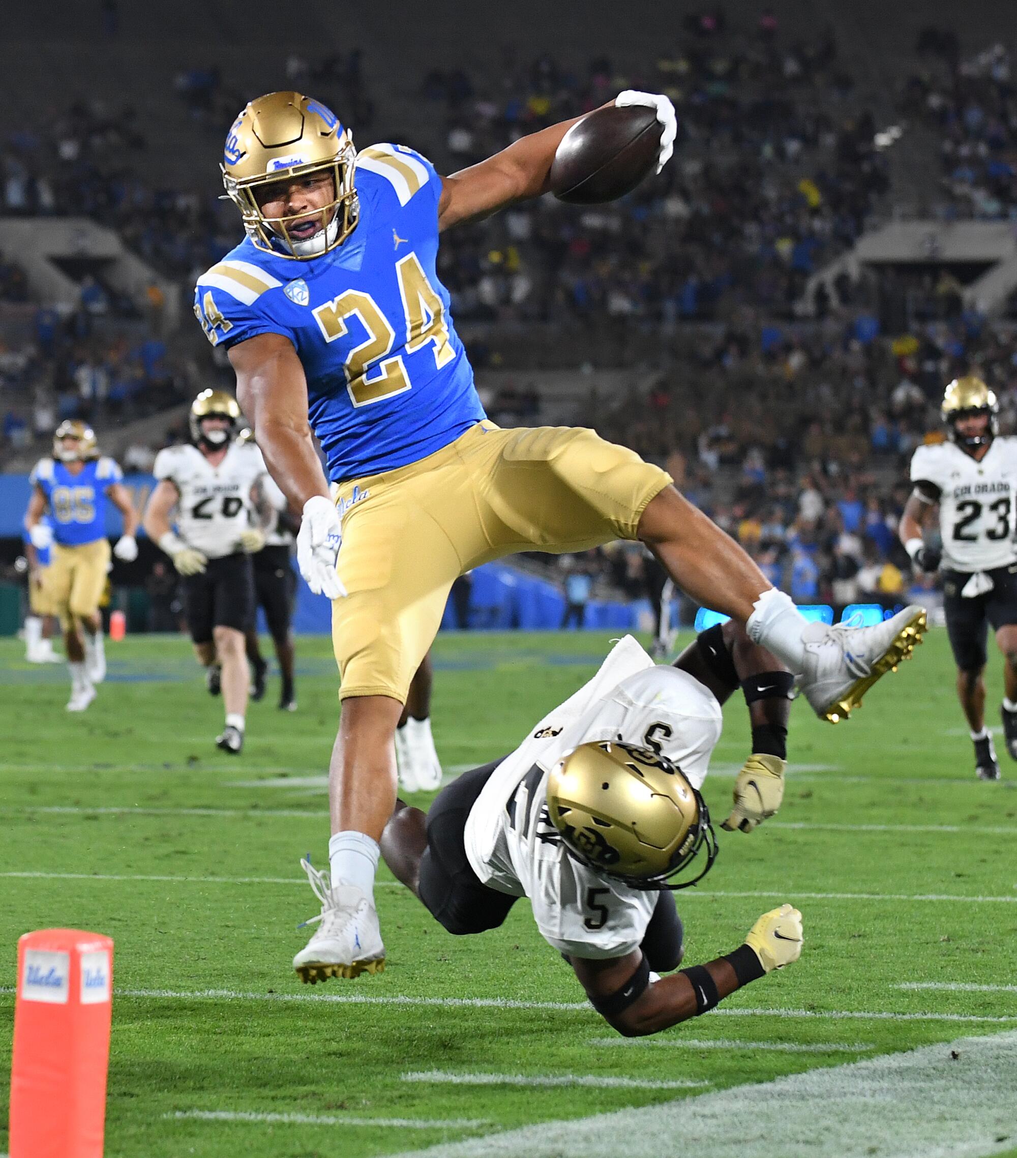 UCLA running back leaps over defense.