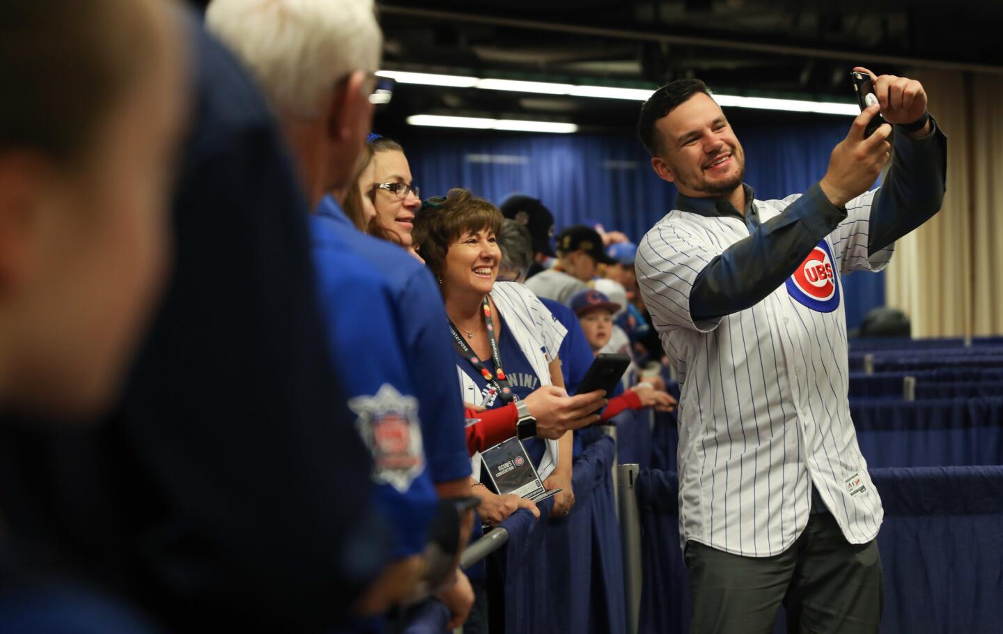 Eileen Geary, center, lends her phone to the Cubs' Kyle Schwarber, for a selfie on Saturday.