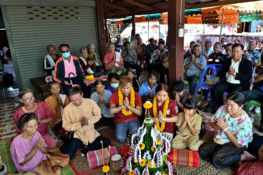 Freed Thai couple Boonthom Pankhong (centre L) and Natthawaree Mulkan (centre R), who were held hostage by Palestinian Hamas militants following the October 7 attack on Israel, take part in a traditional welcoming ceremony for their safe return to Thailand, at their house in Thailand's northeastern Udon Thani province on December 6, 2023. (Photo by Manan VATSYAYANA / AFP) (Photo by MANAN VATSYAYANA/AFP via Getty Images)