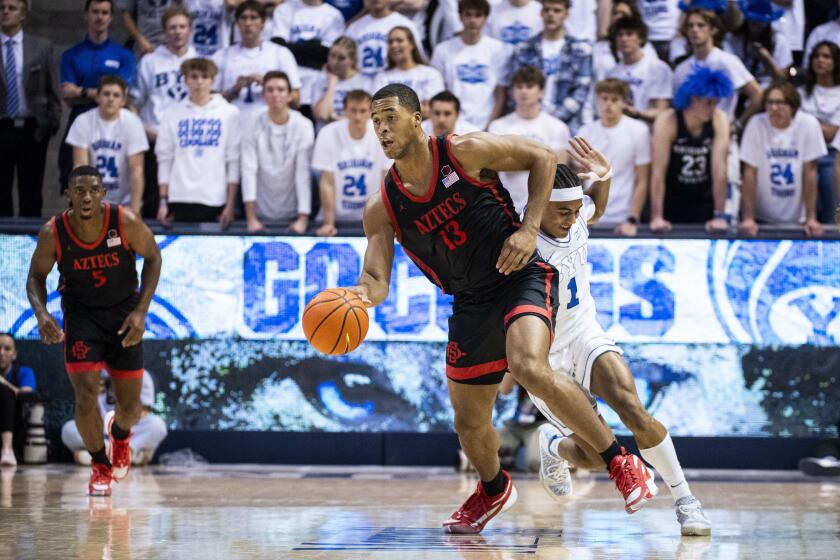 San Diego State forward Jaedon LeDee (13) and BYU guard Trey Stewart (1) collide as they compete for possession of the ball during the first half of an NCAA college basketball game Friday, Nov. 10, 2023, in Provo, Utah. (AP Photo/Isaac Hale)