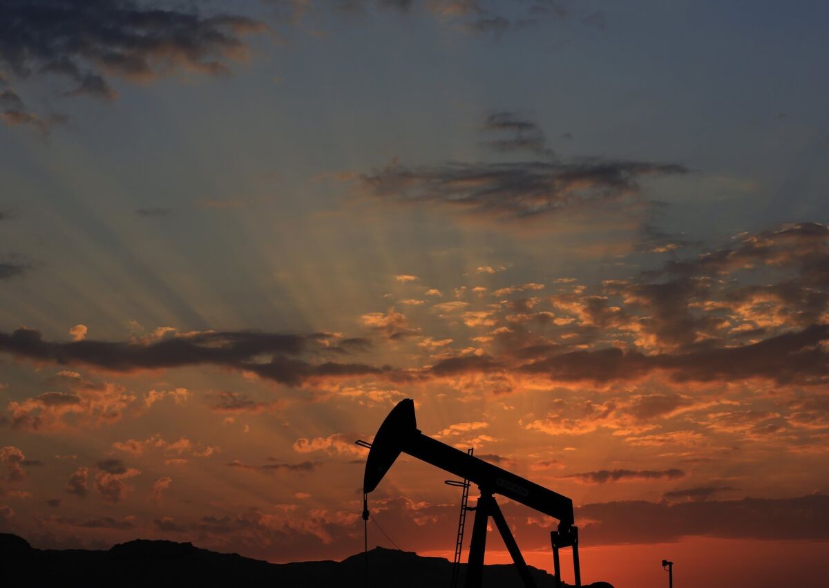 An oil pump at sunset in the desert oil fields of Sakhir, Bahrain on Dec. 13. Gasoline prices remain low in the United States and are expected to soon drop below $2 a gallon.