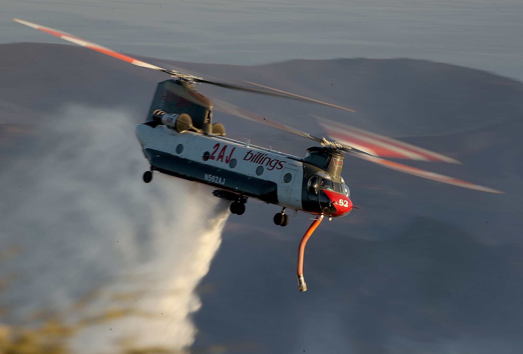 A firefighting helicopter drops water on the Alisal fire near Goleta on Wednesday.