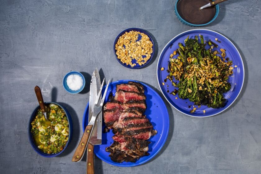 LOS ANGELES, CA--JUNE 13, 2019--Aged ribeye steak with a side of sea salt, pistachio gremolata, charred balsamic broccolini with peanuts and Balsamic vinaigrette, from Vartan Abgaryan at Yours Truly in Venice, photographed on a Los Angeles, CA, rooftop, June 13, 2019, as part of a "best beef to grill on fourth of July." Selected meat: Aged ribeye steak with pistachio gremolata and charred balsamic broccolini (from Vartan Abgaryan at Yours Truly in Venice), Prime hangar steak with szechuan spices and citrus (from chef Brandon Kida, at Hinoki & the Bird in Century City), dry-aged burger with gruyere and homemade mayonnaise (adapted from Katie Flannery, at Flannery Beef) and skirt steak with marjoram and lime salsa, from writer Ben Mims. (Jay L. Clendenin / Los Angeles Times)