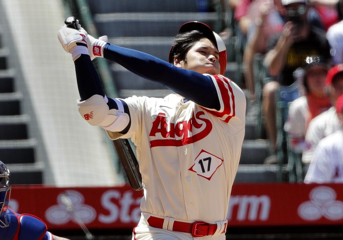 Angels star Shohei Ohtani loses his helmet on a hard swing against the Texas Rangers in the third inning Sunday.