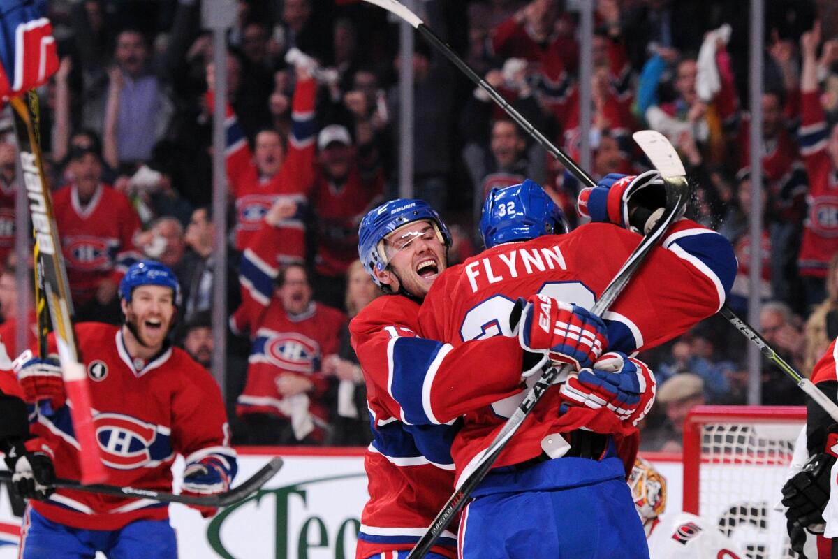 Canadien teammates Torrey Mitchell, center, and Brian Flynn celebrate after Flynn scored in the second period. The Canadiens defeated the Senators, 4-3.