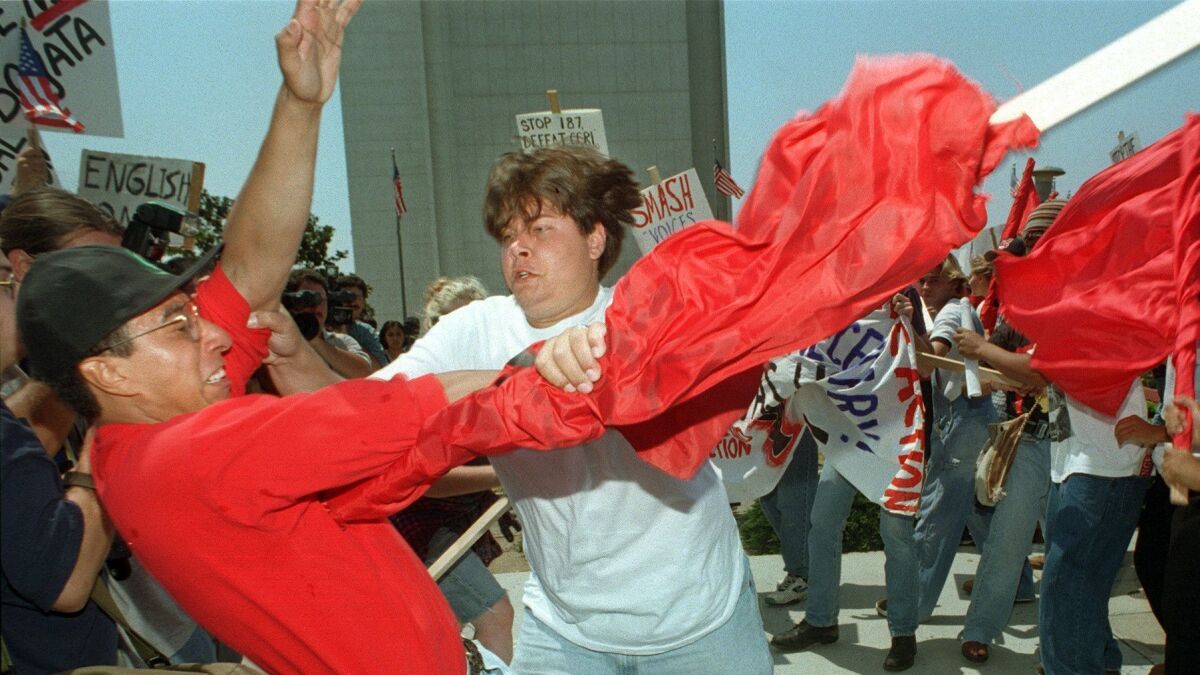 A pro-187 supporter, center with white shirt, gets in to a scuffle with an anti-187 protestor in Los Angeles on August 10, 1996.