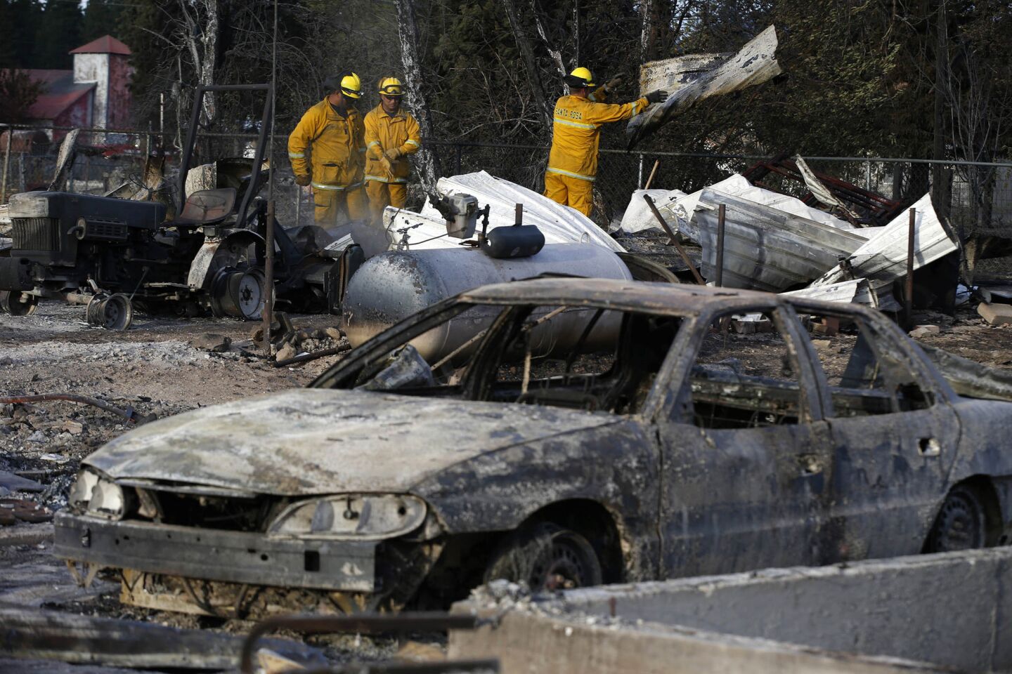 Santa Rosa city firefighters clear debris in search of hot spots in the Angel Valley neighborhood of Weed, Calif., where many homes were destroyed by the Boles fire.