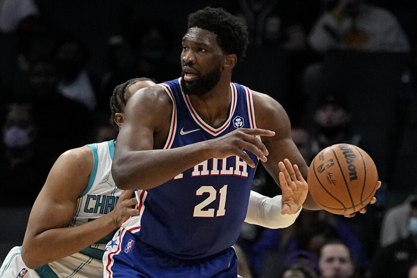 Charlotte Hornets forward P.J. Washington knocks the ball away from Philadelphia 76ers center Joel Embiid during the first half of an NBA basketball game on Monday, Dec. 6, 2021, in Charlotte, N.C. (AP Photo/Chris Carlson)