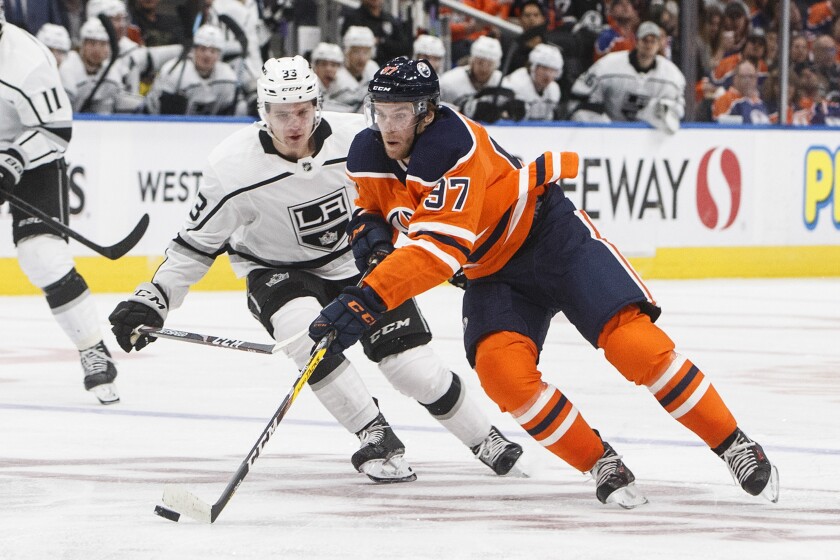 The Kings' Tobias Bjornfot chases the Oilers' Connor McDavid on Saturday night in Edmonton, Canada.