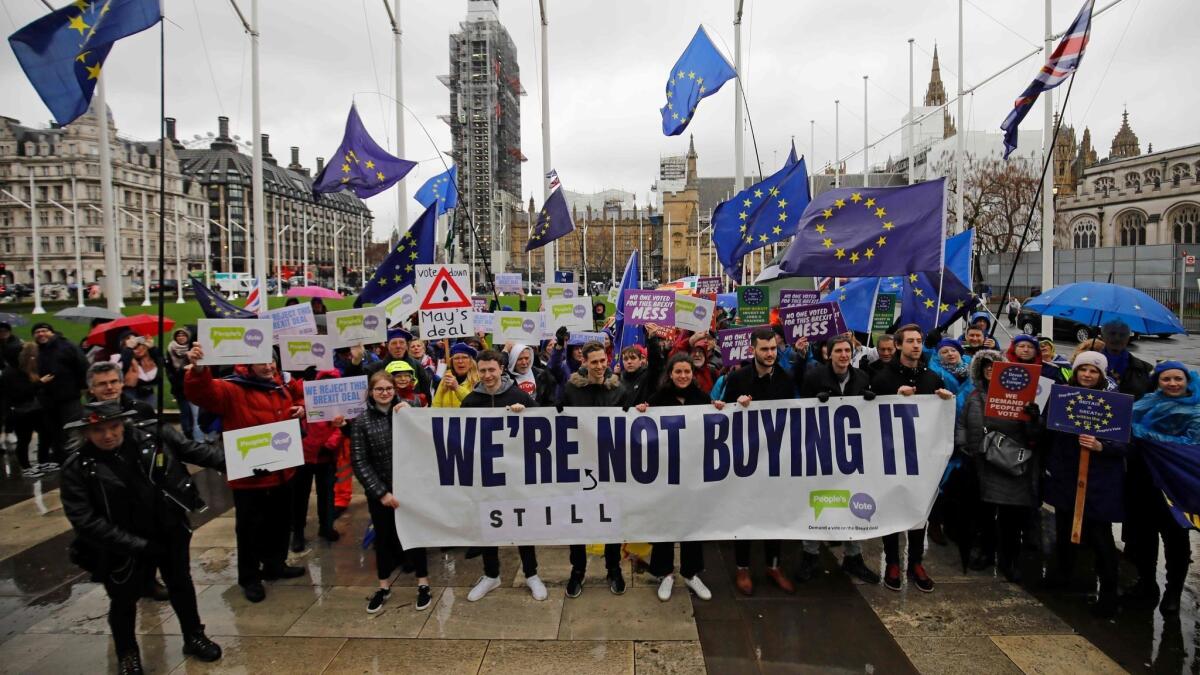 Anti-Brexit activists demonstrate outside the Houses of Parliament in London on March 12, 2019.