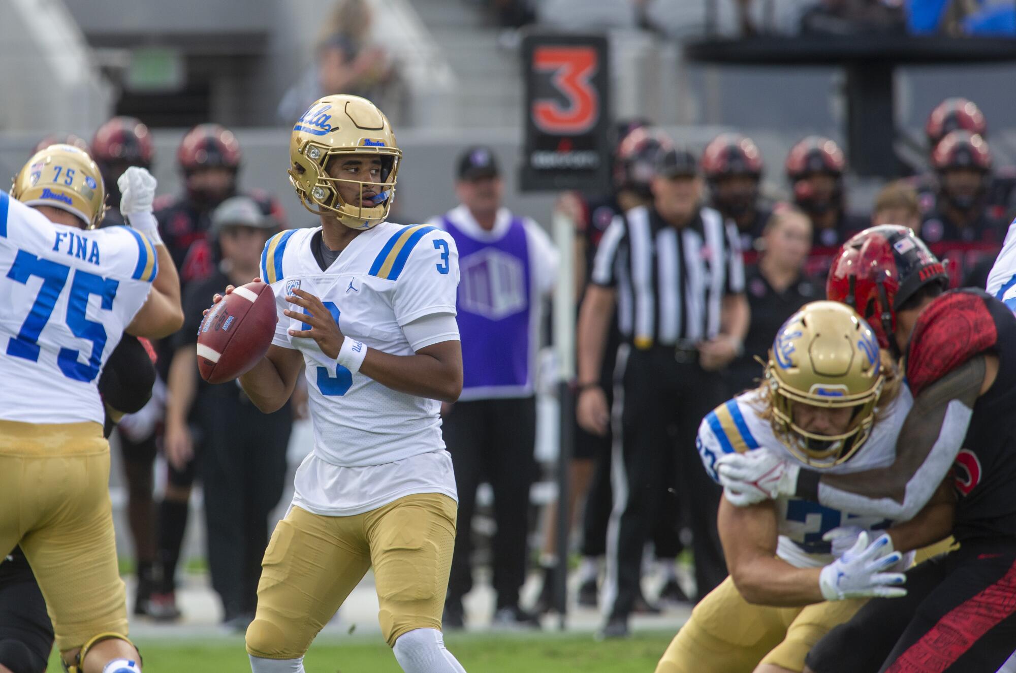 UCLA quarterback Dante Moore stands in the pocket while looking downfield for a receiver.