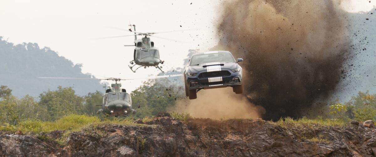 Two helicopters pursue a car in a scene from “F9” a.k.a. “Fast & Furious Nine.”