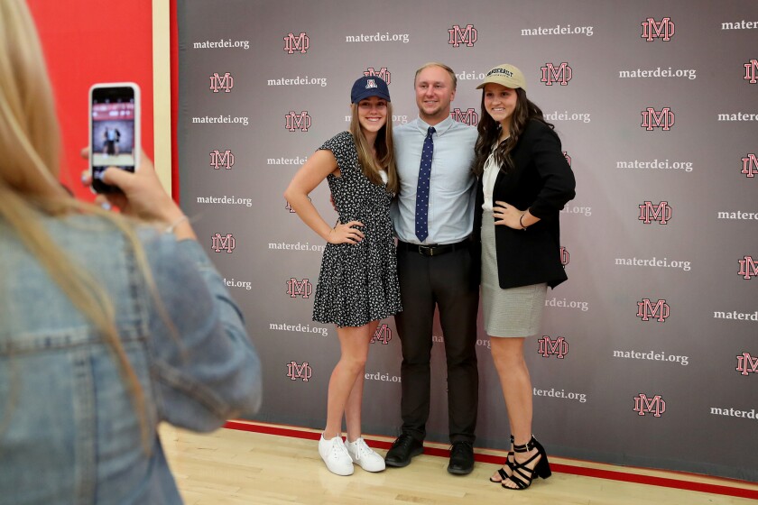Senior Kailia Utley, right, smiles for pictures with coach Kelly Dullard, center, and fellow senior swimmer Lizzie Mackowiak.