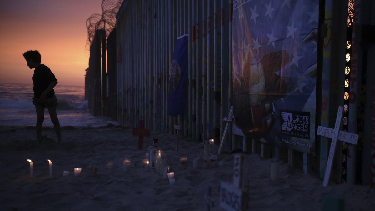 Candles and crosses stand Tijuana in memory of migrants who died during their journey toward the U.S.