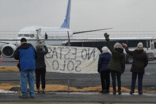 Activists in Yakima, Wash., wave encouragement to a detainee in shackles boarding a U.S. Immigration and Customs Enforcement flight bound for Mesa, Arizona. ICE moved the flights to the central Washington city in May after King County officials booted them from Boeing Field near Seattle, saying deportations raised troubling human rights concerns.