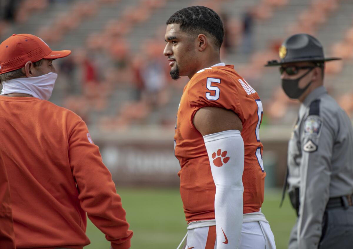 Clemson coach Dabo Swinney and quarterback DJ Uiagalelei walk off the field after the Tigers beat Boston College 34-28.