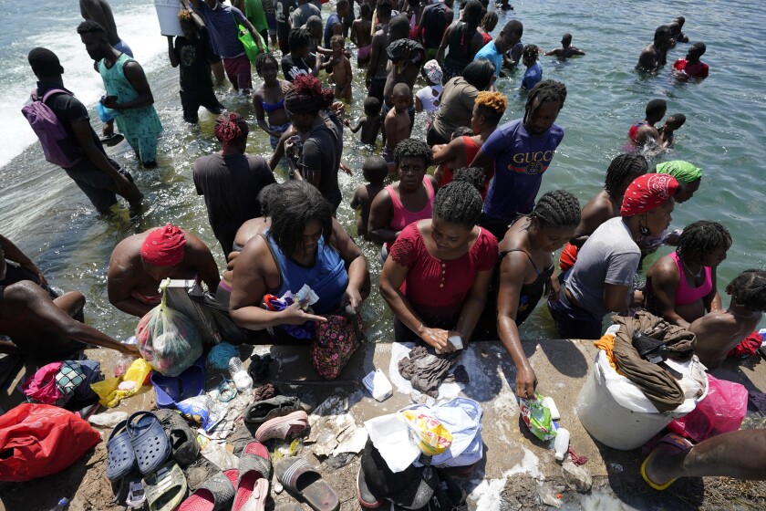 Haitian migrants use a dam.