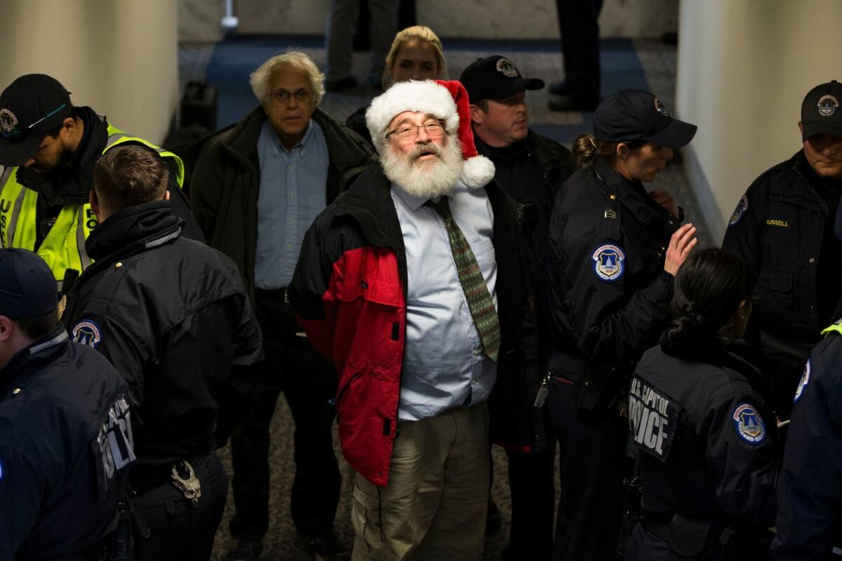 U.S. Capitol Police arrest a bearded man with a Santa Claus hat during a protest against the Republican tax reform on Capitol Hill.