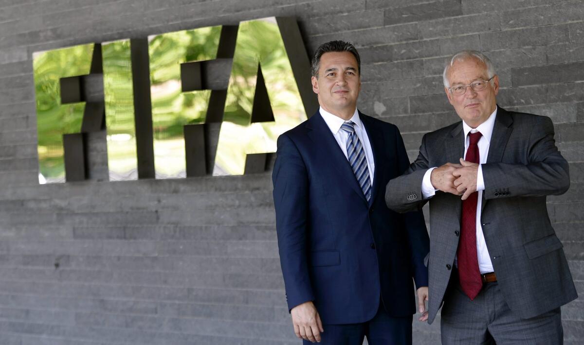 Michael Garcia, left, and Hans-Joachim Eckert stand outside FIFA headquarters Zurich, Switzerland, in 2012.