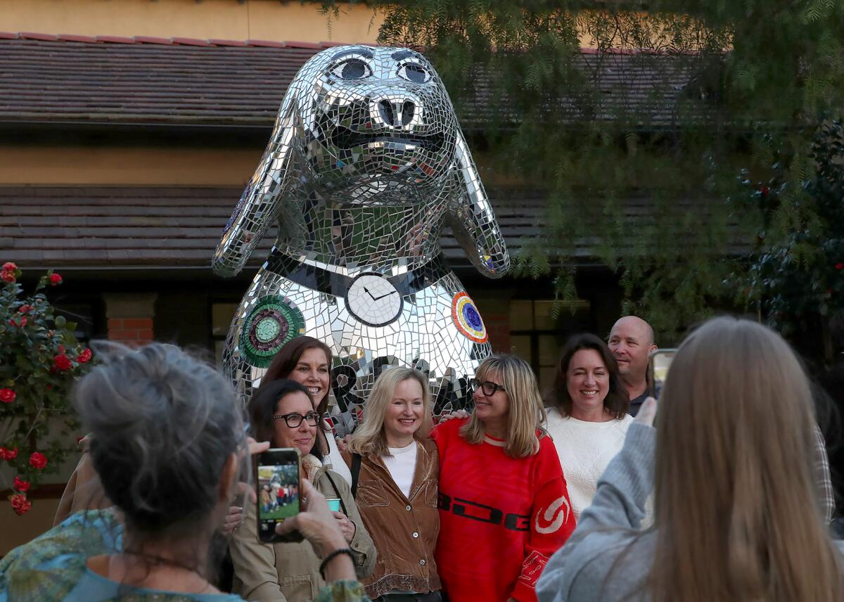 Elizabeth Laul Healey, in red, stands near her "Dream Big," sculpture with close friends from Laguna Beach High.