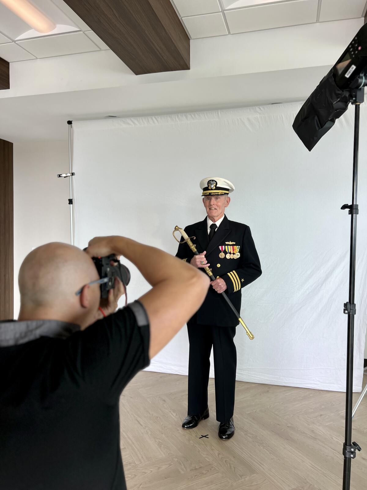 Thomas Sanders photographs Bill Massicot, a naval commander who served from 1960 to 1988, in full dress uniform.