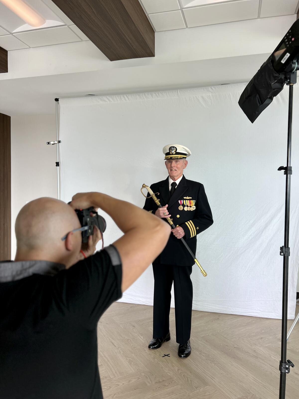 Thomas Sanders photographs Bill Massicot, a naval commander who served from 1960 to 1988, in full dress uniform.