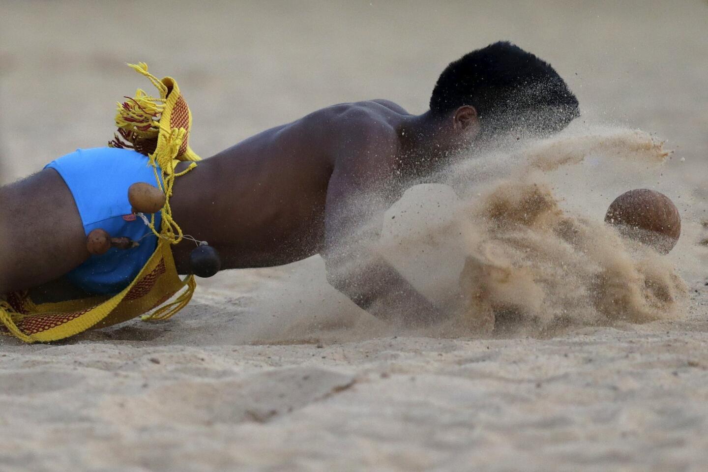 An indigenous man from the Paresi tribe tries to head the ball during the Jikunahati competition, a form of soccer played with one's head, at the first World Games for Indigenous Peoples in Palmas