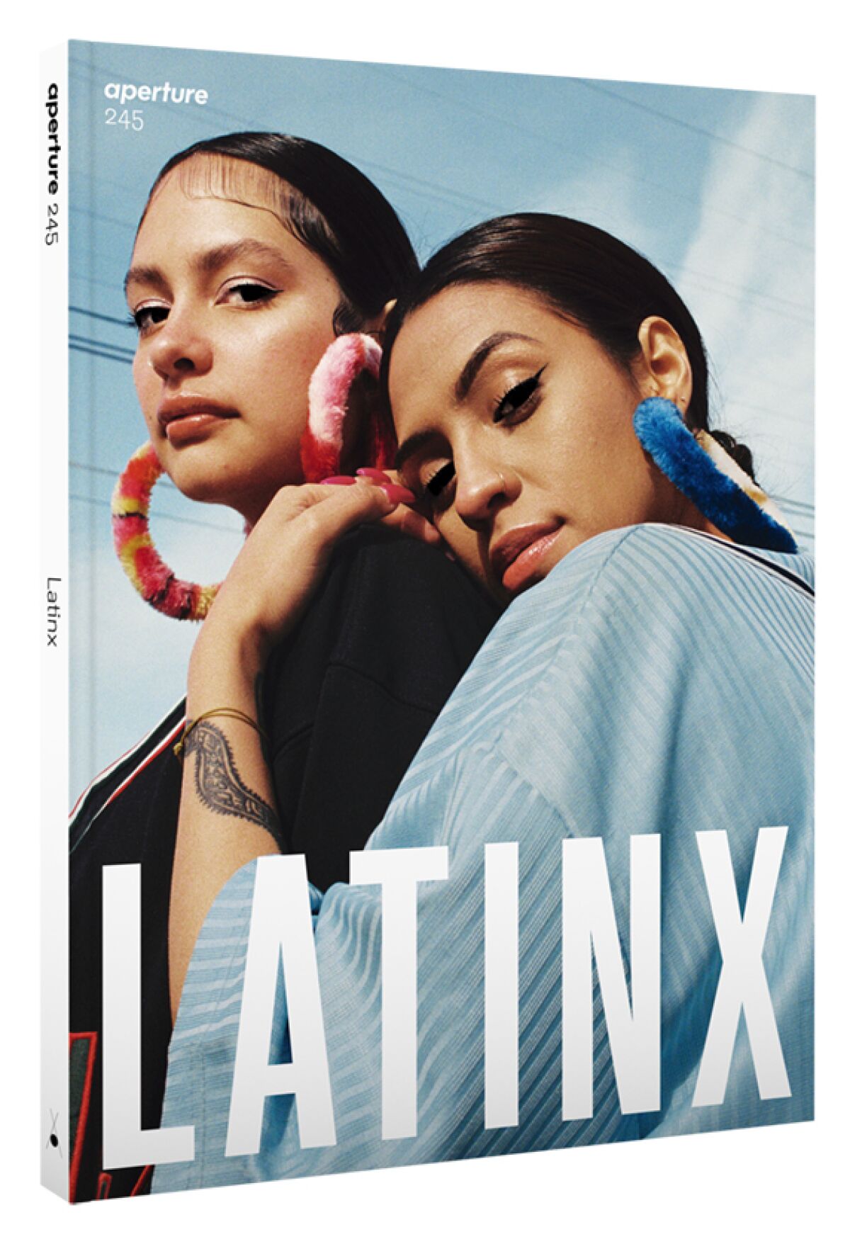 A magazine cover shows two young women embracing and the word "Latinx"