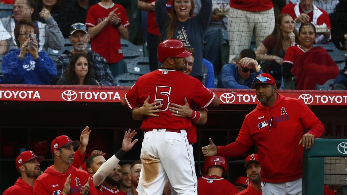 Angels' Albert Pujols (5) gets a hug from teammate Mike Trout (27) after hitting a two-run home run against the Dodgers in the fourth inning.