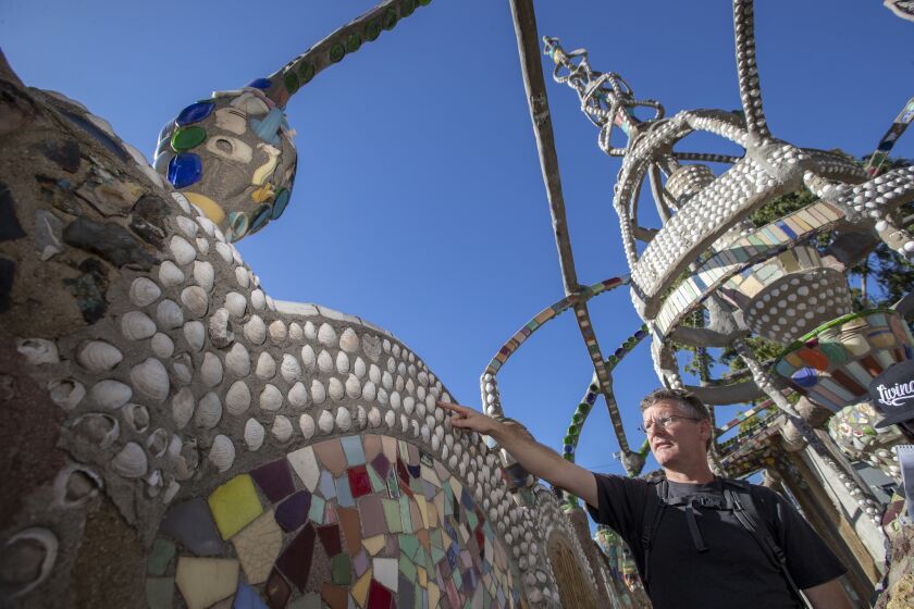WATTS, CALIF. -- WEDNESDAY, NOVEMBER 14, 2018: Dr. Bruno Pernet, Invertebrate Biology professor at Cal State University Long Beach, studies the shells on the Watts Towers to learn what they can teach us about marine life in the area, especially with respect to invasive species at the Watts Towers on Nov. 14, 2018. Since 2011, as a passion project, Pemet found that of the 10,000 shells on the Towers and the 34 species represented, 29 were native to the area. Some, like the venus clam and Japanese little neck, are less pervasive now because of invasive species pushing them out. The towers, sculptures, structures, pavement and walls were designed and built by Sabato ("Simon") Rodia over a period of 33 years from 1921 to 1954. Watts Towers are a collection of 17 interconnected sculptural towers, individual sculptural features, architectural structures, and mosaics located on the site of the artist's original residential property. (Allen J. Schaben / Los Angeles Times)
