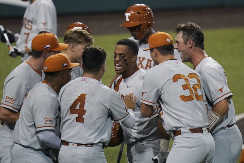 Texas' Camryn Williams, center, celebrates a two-run homer against South Florida during the seventh inning of an NCAA Super Regional college baseball game, Sunday, June 13, 2021, in Austin, Texas. (AP Photo/Eric Gay)