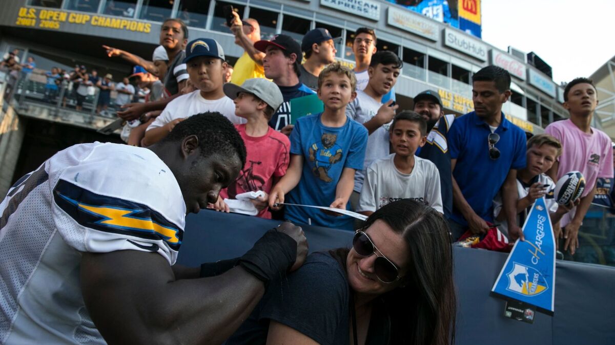 Chargers linebacker Jeremiah Attaochu autographs the shirt of fan Carrie O'Leary following a practice with the Rams at StubHub Center.