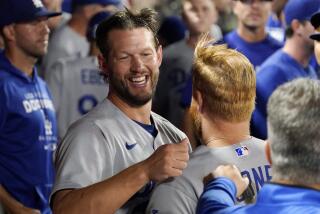 Los Angeles Dodgers starting pitcher Clayton Kershaw, left, hugs Justin Turner after the eighth inning.
